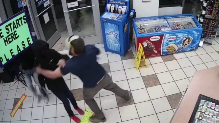man grabbing suspect in gas station
