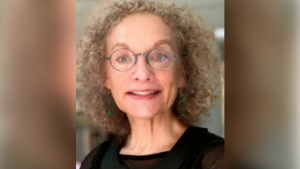 Smiling woman with curly hair and glasses