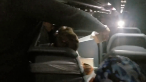Passenger Maxwell Berry seen from behind being duct-taped to his seat