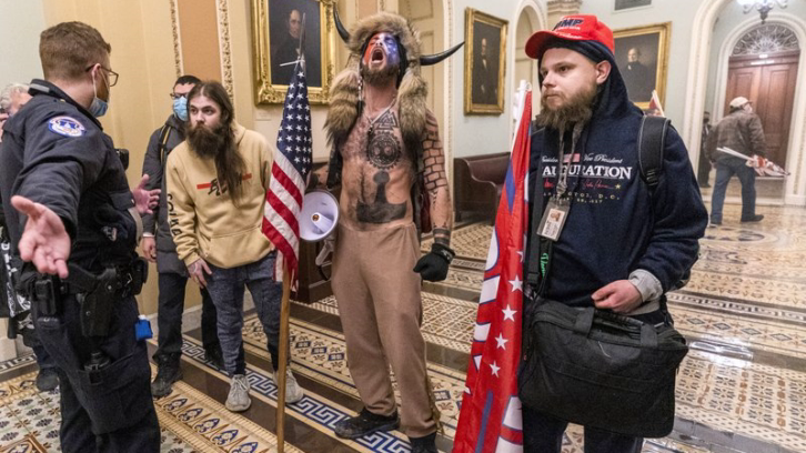 Supporters of President Donald Trump, including Jacob Chansley (center with fur hat), being confronted by Capitol Police officers outside the Senate Chamber inside the Capitol in Washington D.C.