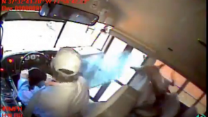 still of bus footage showing deer landing on a sleeping student in the first row